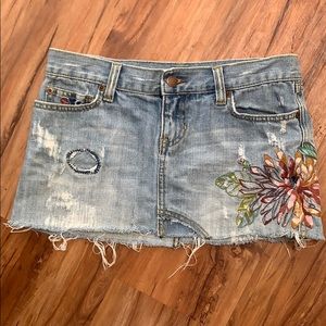 Distressed denim miniskirt with floral embroidery